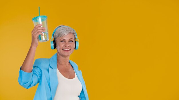 Portret stylowej starszej kobiety z parą słuchawek