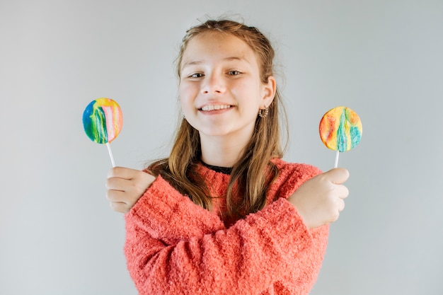 Bezpłatne zdjęcie portret szczęśliwa dziewczyny mienia lollipops