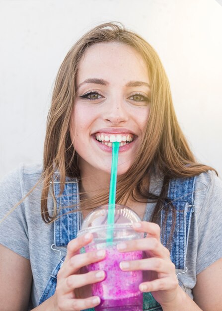 Portret szczęśliwa młoda kobieta pije sok