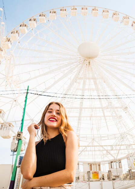 Portret szczęśliwa młodej kobiety pozycja przed gigantycznymi ferris kołem