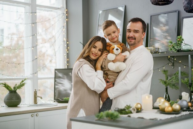 Portret szczęśliwej rodziny w kuchni udekorowanej na Boże Narodzenie