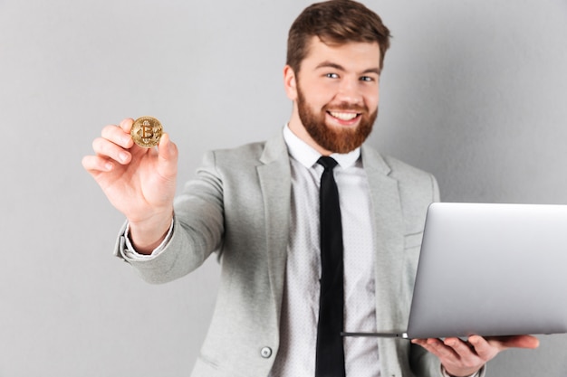 Bezpłatne zdjęcie portret szczęśliwy biznesmen pokazuje bitcoin