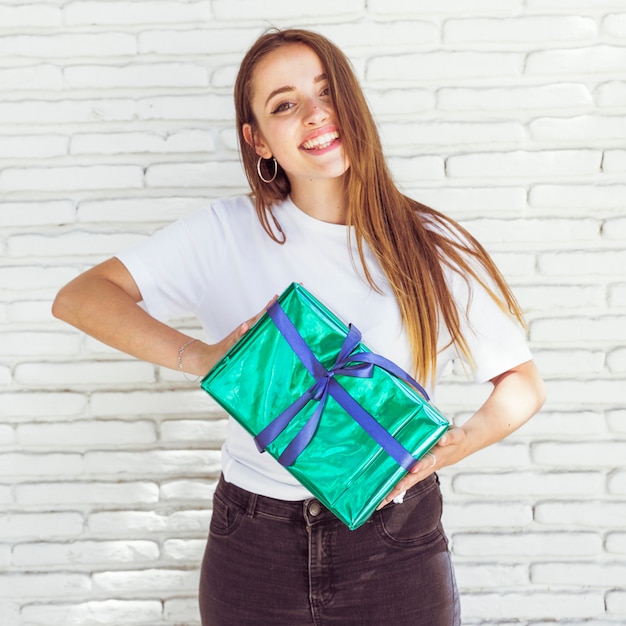 Bezpłatne zdjęcie portret szczęśliwy kobiety mienia zieleni prezenta pudełko