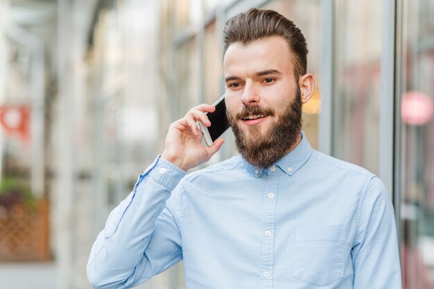 Portret szczęśliwy mężczyzna opowiada na telefonie komórkowym