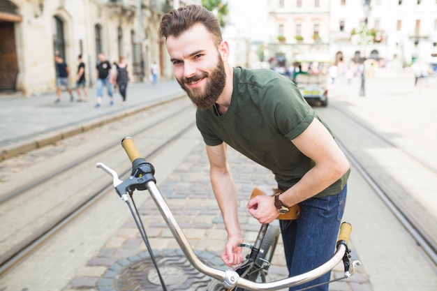 Portret Szczęśliwy Młody Człowiek Przystosowywa Rowerowego Siedzenia