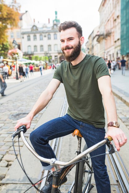 Portret szczęśliwy młody człowiek z bicyklem