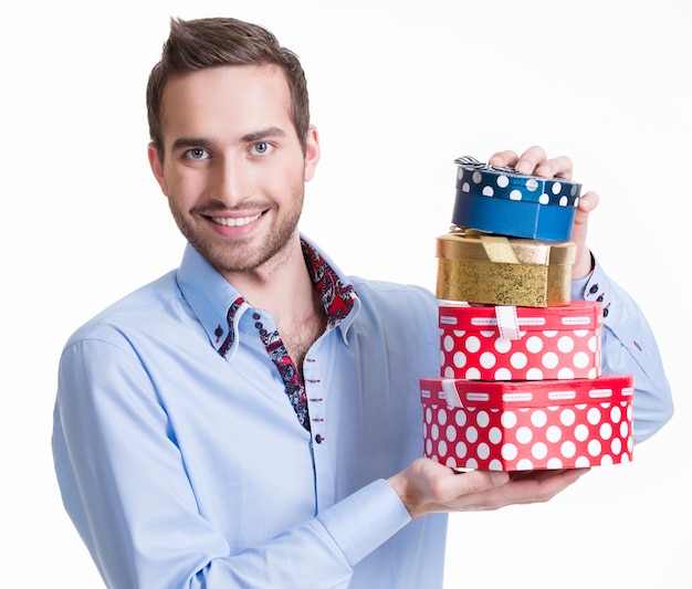 Bezpłatne zdjęcie portret szczęśliwy młody człowiek z prezentami - na białym tle