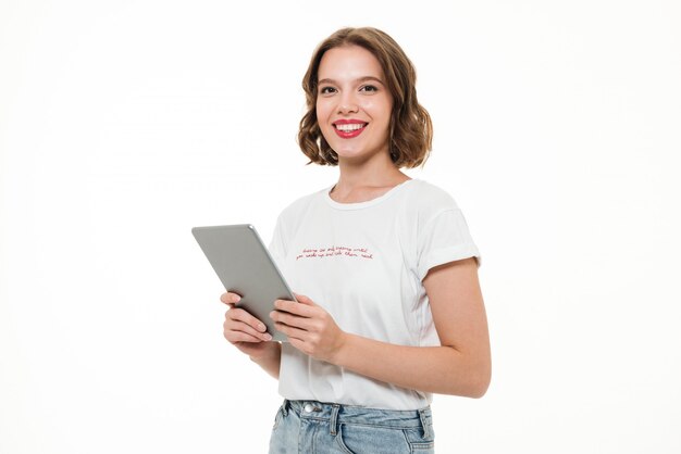 Portret szczęśliwy uśmiechnięty dziewczyny mienia pastylki komputer