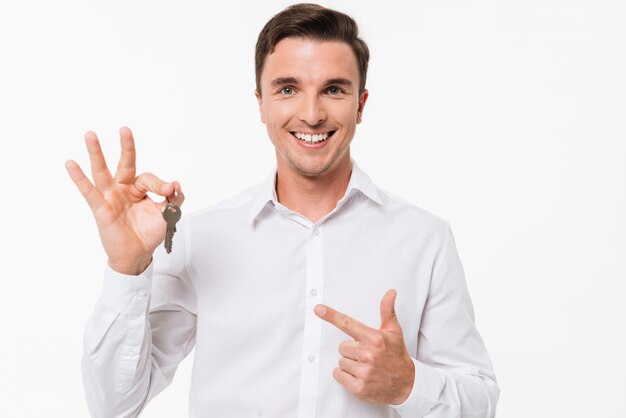 Portret szczęśliwy uśmiechnięty mężczyzna w koszuli gospodarstwa klucze