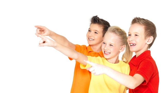 Bezpłatne zdjęcie portret szczęśliwych dzieci wskaż palcem na coś daleko - na białym tle