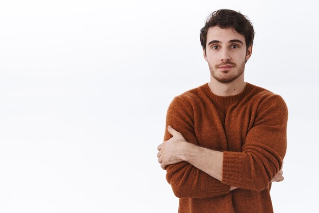 Portret talii w górę atrakcyjnego młodego 25-letniego mężczyzny w brązowej bluzie