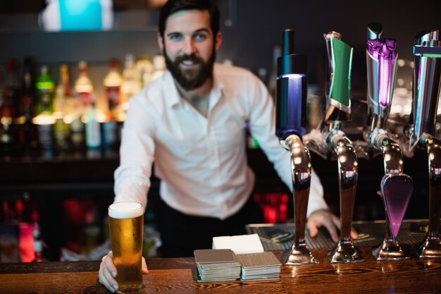 Portret trzyma szklankę piwa barman