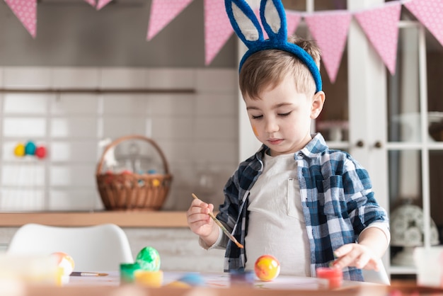 Portret Urocza Chłopiec Maluje Jajka Dla Easter