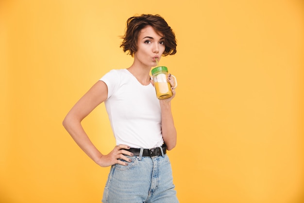 Portret urocza przypadkowa kobieta pije sok pomarańczowego