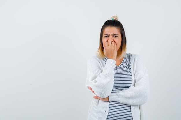 Portret uroczej damy gryzącej paznokcie emocjonalnie w koszulce, swetrze i wyglądającym na niespokojny widok z przodu