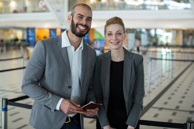 Portret uśmiechnięci biznesmeni z paszportem czekają w kolejce