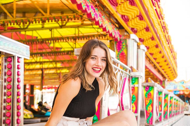 Portret uśmiechnięta młoda kobieta przy parkiem rozrywki