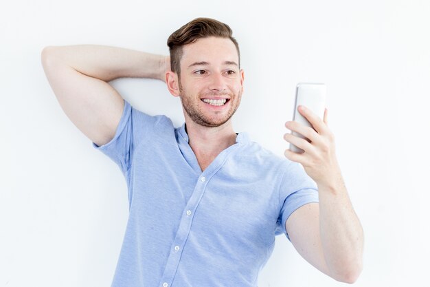 Portret uśmiechnięta młody człowiek stwarzających dla selfie