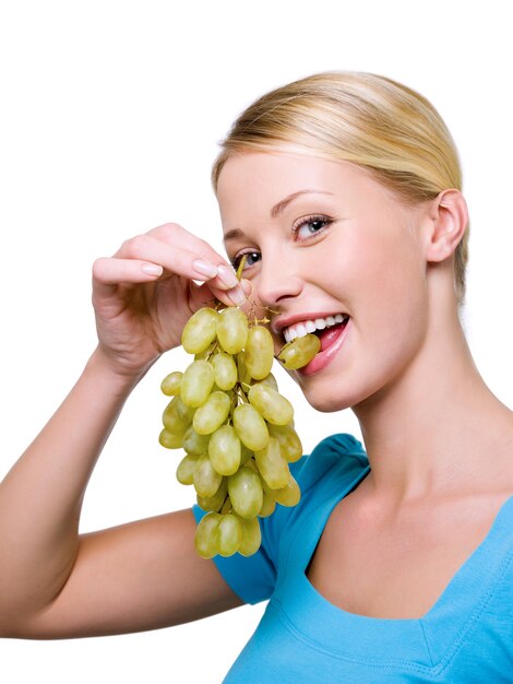 Portret uśmiechnięta Piękna kobieta gryzie winogrona -