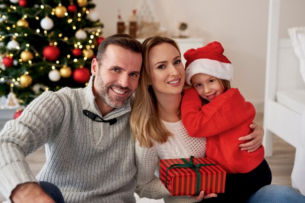 Portret uśmiechnięta rodzina z prezentem na Boże Narodzenie