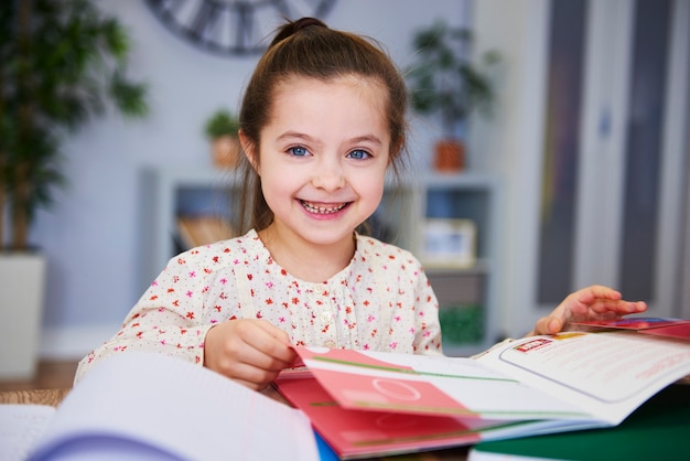 Portret Uśmiechniętego Dziecka Studiującego W Domu At Premium Zdjęcia