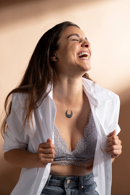 Bezpłatne zdjęcie portret uśmiechniętej kobiety pozującej w białej koszuli