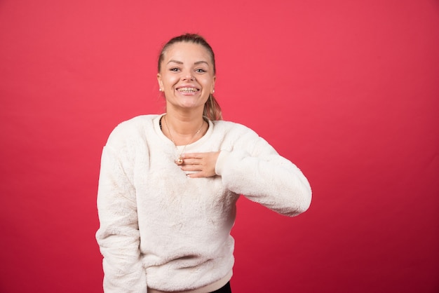 Portret uśmiechniętej kobiety, wskazując na siebie