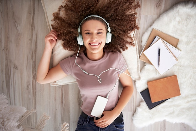 Portret uśmiechniętej nastoletniej dziewczyny słuchającej muzyki