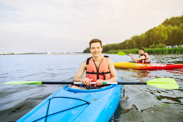 Portret uśmiechnięty męski kajakarz kayaking na jeziorze