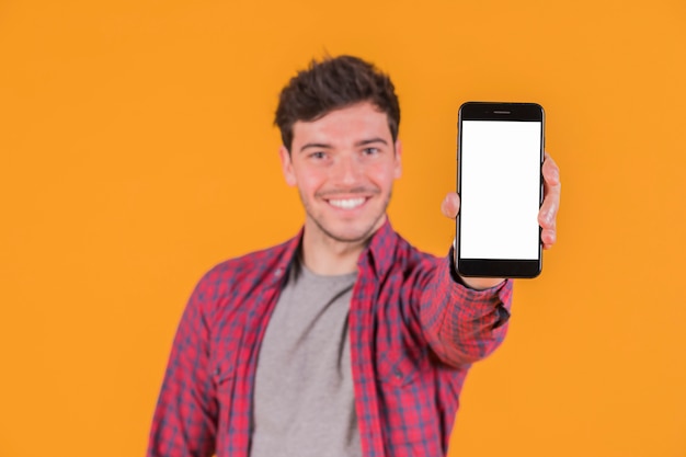 Portret uśmiechnięty młody człowiek pokazuje pustego bielu ekranu telefon komórkowego