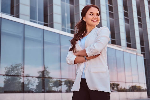 Portret Wesołej Buisnesswoman Sukcesu Na Tle Szklanego Budynku.