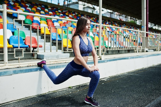 Bezpłatne zdjęcie portret wspaniałej dziewczyny robi przysiady na stadionie