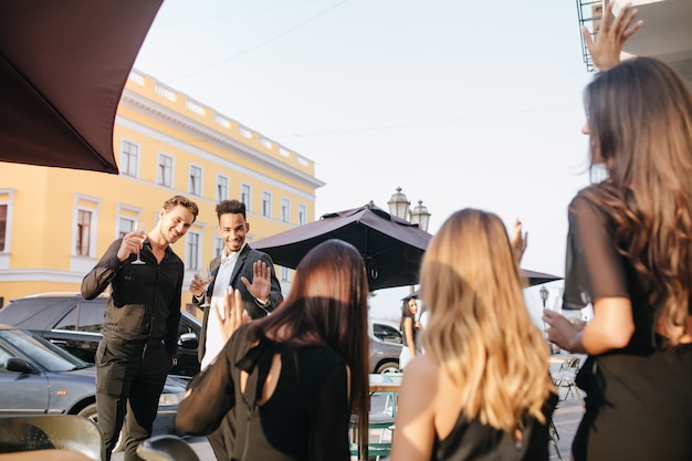 Portret z tyłu trzech kobiet z długimi lśniącymi włosami, patrząc na mężczyzn z tyłu