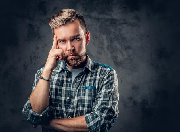 Portret zadumany brodaty mężczyzna hipster na szarym tle.