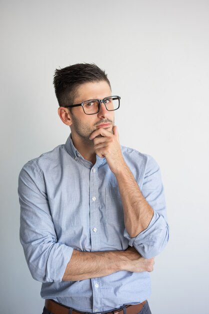 Portret zadumany młody biznesmen jest ubranym eyeglasses.