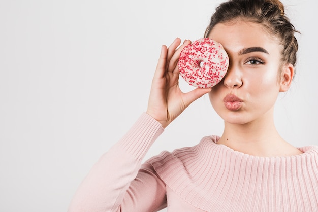 Portret zakrywa ona oczy z donuts ładna młoda kobieta