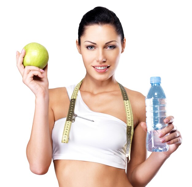Portret zdrowej kobiety z jabłkiem i butelką wody. Zdrowe fitness i koncepcja stylu życia odżywiania.