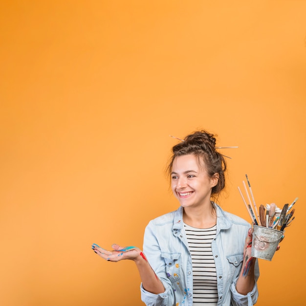 Bezpłatne zdjęcie portret żeński artysta z paintbrushes