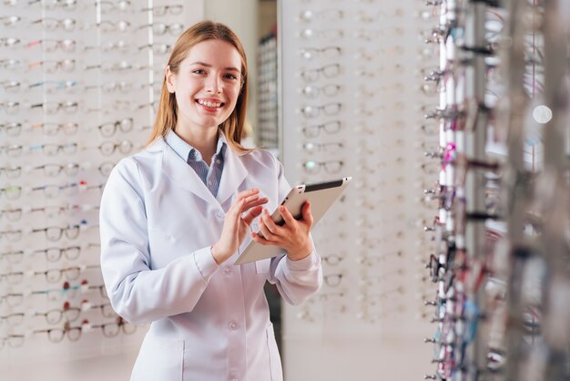 Portret życzliwy żeński optometrist używa pastylkę