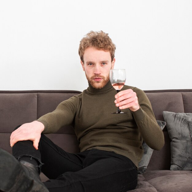 Portreta młody samiec pije wino