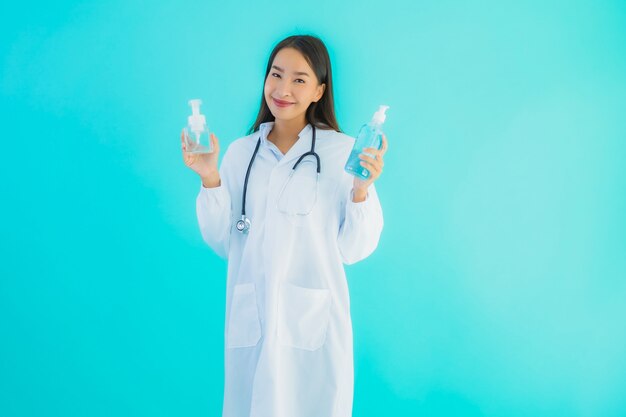 Portreta piękna młoda azjata lekarki kobieta z gel alkoholem dla czystej ręki