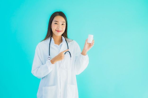 Portreta piękna młoda azjata lekarki kobieta z lek medycyny butelką