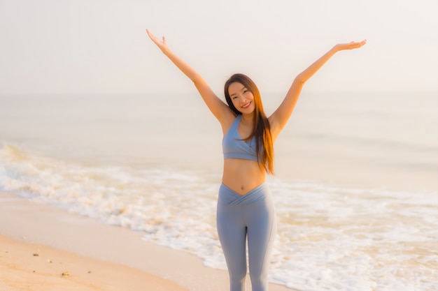 Portreta Sporta Młoda Azjatykcia Kobieta Przygotowywa ćwiczenie Lub Bieg Na Plażowym Dennym Oceanie
