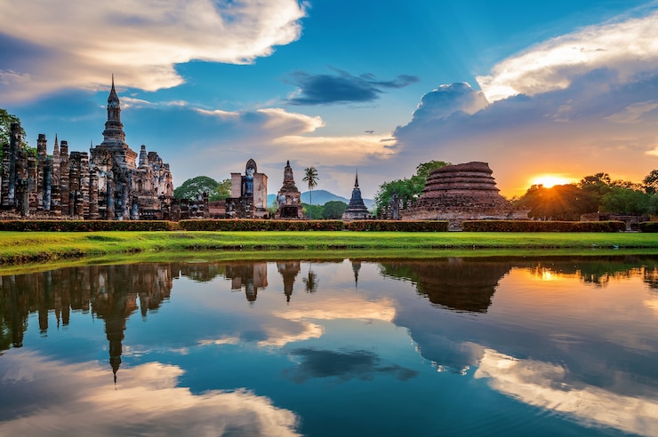 Bezpłatny plik Zdjęcie posąg buddy i świątynia wat mahathat na obrzeżach parku historycznego sukhothai