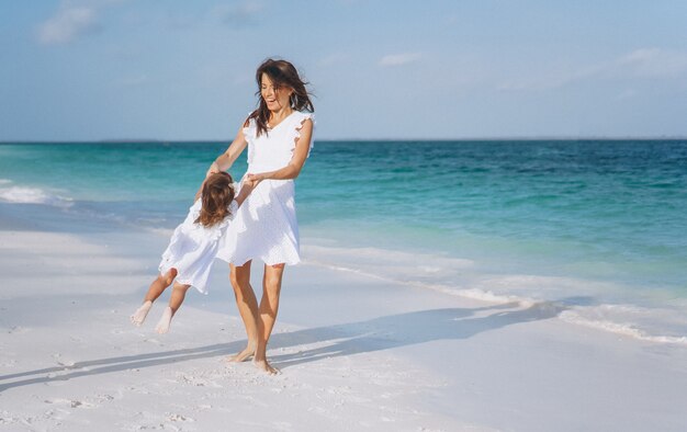 Potomstwa matkują z jej małą córką przy plażą oceanem