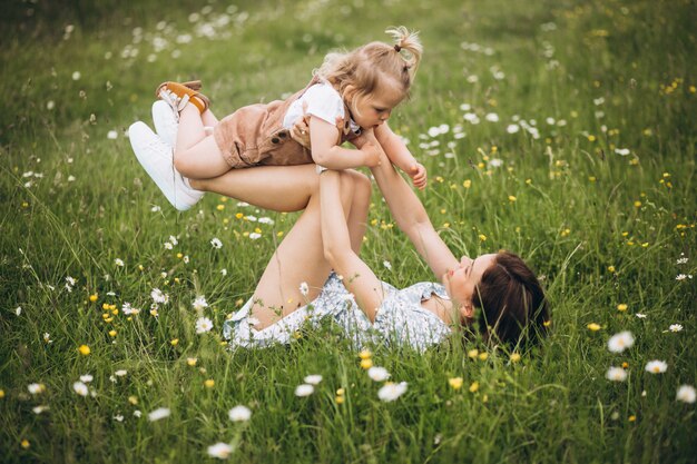 Potomstwa matkują z małą córką w parkowym obsiadaniu na trawie