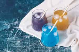 Bezpłatne zdjęcie potrójne kolorowe kubki napoju na niebiesko.