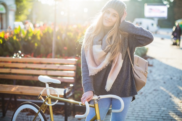 Powabna kobieta pozuje blisko bicyklu