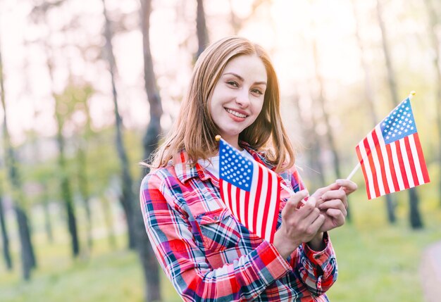 Powabna młoda kobieta z flaga amerykańskimi