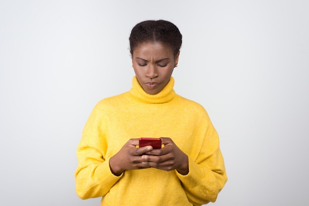 Poważna amerykanin afrykańskiego pochodzenia kobieta texting na smartphone